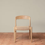 Chaise d'appoint - Disponible en plusieurs finitions, ses lignes sculpturales, son dossier incurvé et son assise généreusement tissée à la main équilibrent forme et texture...