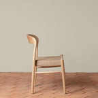 Chaise d'appoint - Disponible en plusieurs finitions, ses lignes sculpturales, son dossier incurvé et son assise généreusement tissée à la main équilibrent forme et texture...