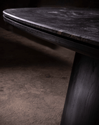 Table de salle à manger - Une étude en contraste — le plateau en quartzite cuiré offre une profondeur tactile qui change avec la lumière, ancré par un mat noir...
