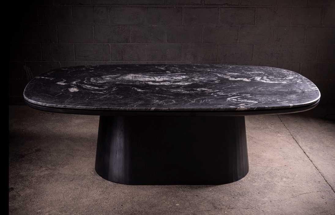 Table de salle à manger - Une étude en contraste — le plateau en quartzite cuiré offre une profondeur tactile qui change avec la lumière, ancré par un mat noir...