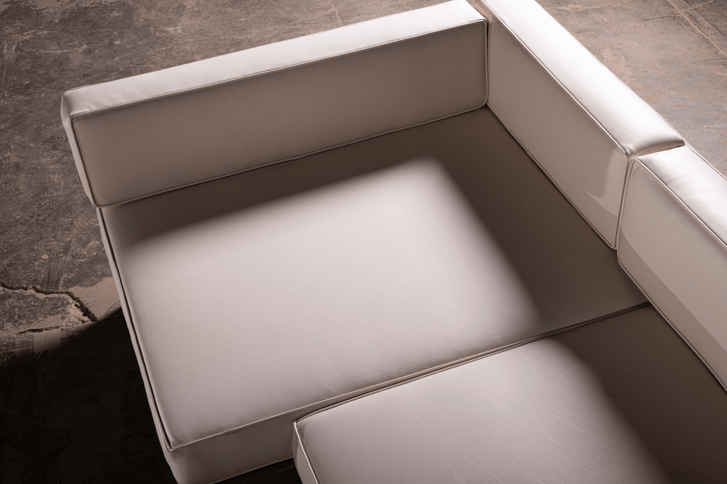 Canapé d'angle en U – Doté d'une base robuste en bois au fini riche et naturel, il est associé à des coussins moelleux en cuir synthétique blanc qui...