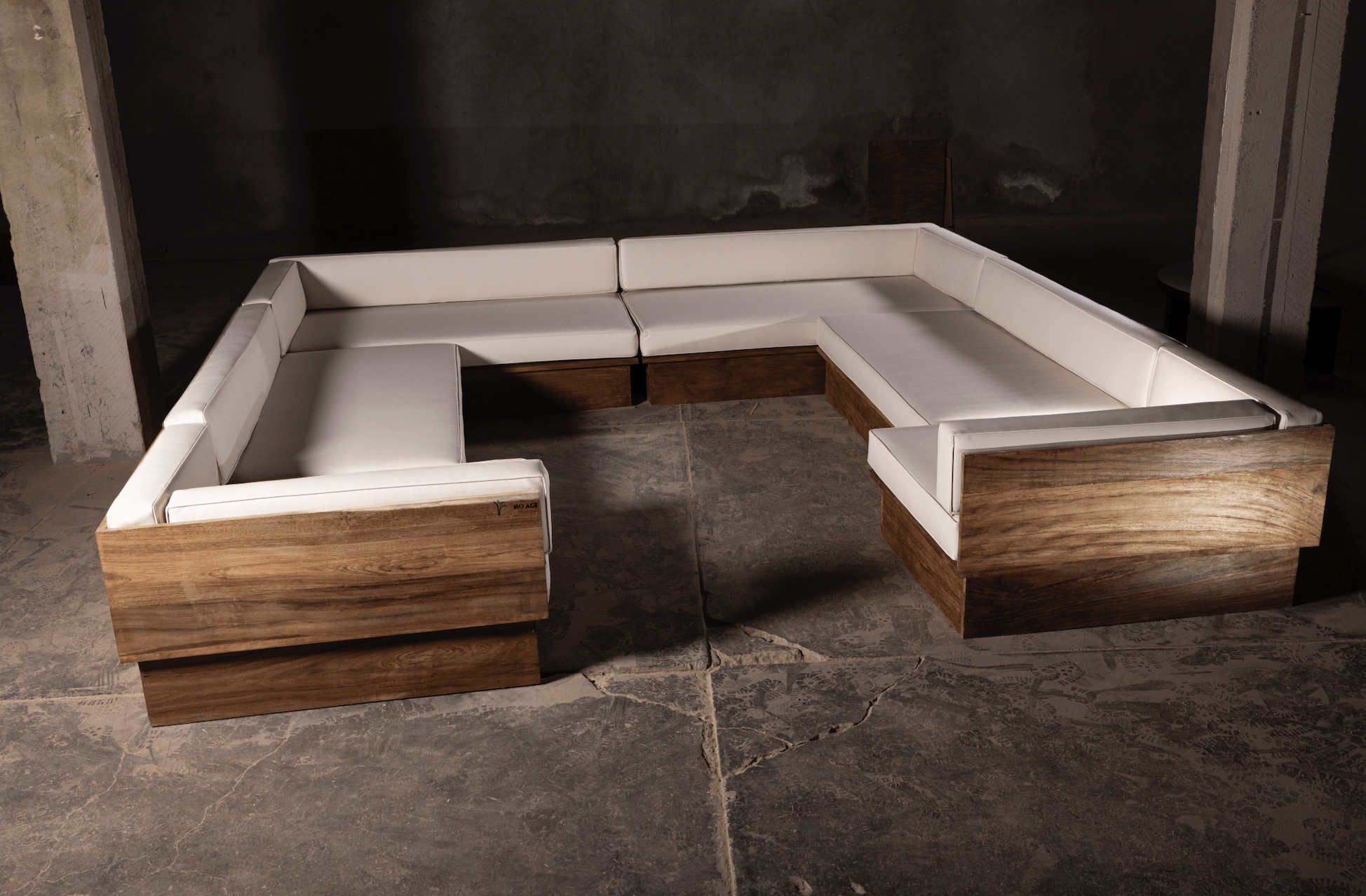 Canapé d'angle en U – Doté d'une base robuste en bois au fini riche et naturel, il est associé à des coussins moelleux en cuir synthétique blanc qui...